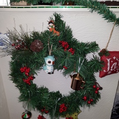 Wreath with ornaments including an owl and a copper kettle