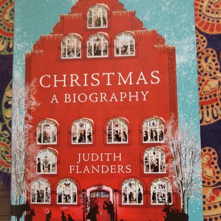 Book cover of a red house in a snowy landscape. 'Christmas: a biography' by Judith Flanders